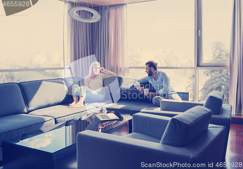 Image of couple relaxing at  home using tablet computer