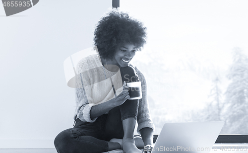 Image of black woman in the living room on the floor