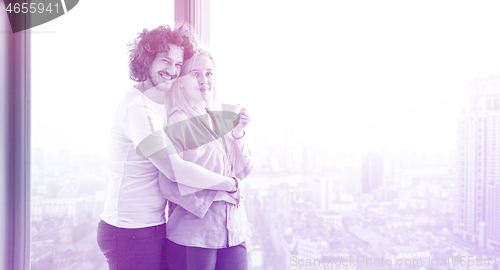 Image of young couple enjoying morning coffee by the window