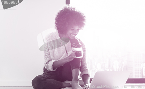 Image of black woman in the living room on the floor