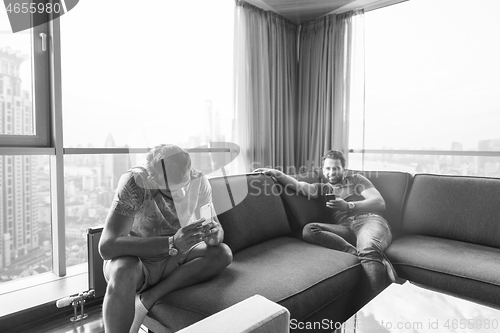 Image of two young men using a mobile phones  at home