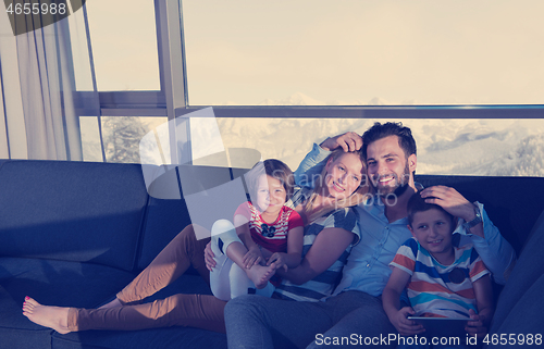 Image of happy young couple spending time with kids at home