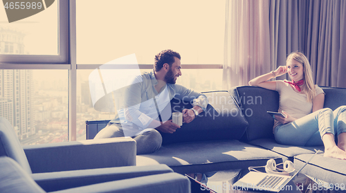Image of couple relaxing at  home using tablet computer