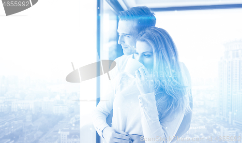 Image of young couple enjoying morning coffee by the window