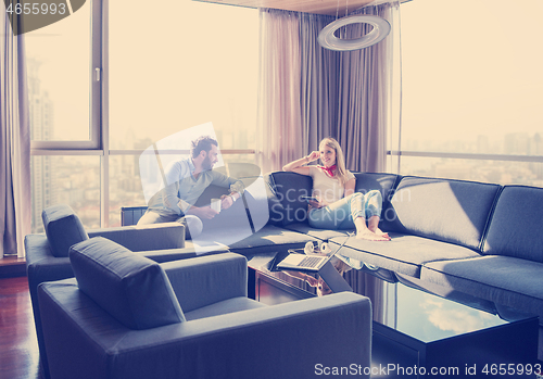 Image of couple relaxing at  home using tablet computer