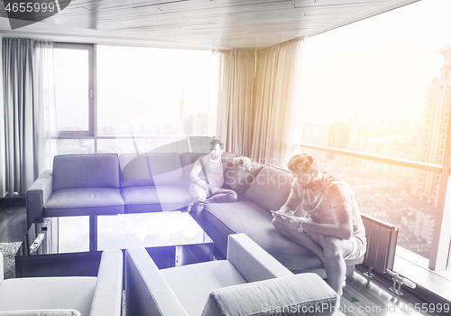 Image of two young men using a mobile phones  at home