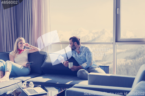 Image of couple relaxing at  home using tablet computer