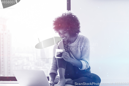 Image of black woman in the living room on the floor