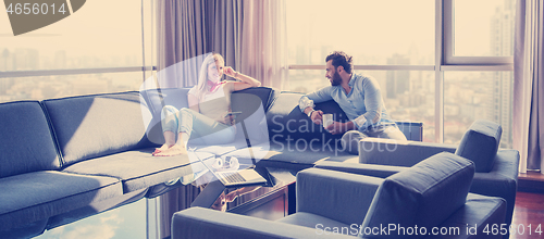 Image of couple relaxing at  home using tablet computer