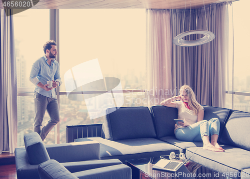 Image of couple relaxing at  home using tablet computer