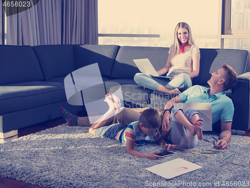 Image of young couple spending time with kids at home