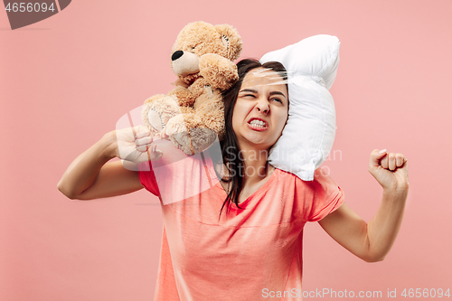 Image of Tired woman sleeping at home having too much work. Bored businesslady with pillow and toy bear