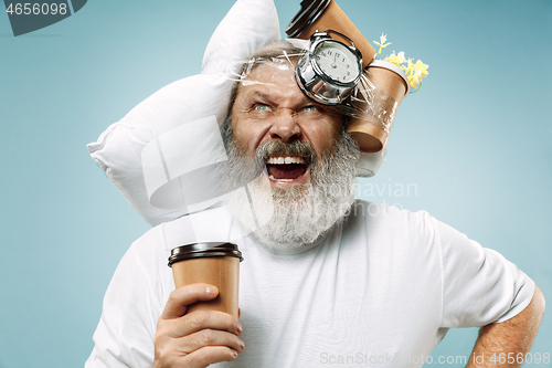 Image of Tired man sleeping at home having too much work. Bored businessman with pillow and hourglass