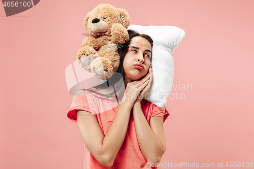 Image of Tired woman sleeping at home having too much work. Bored businesslady with pillow and toy bear