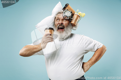 Image of Tired man sleeping at home having too much work. Bored businessman with pillow and hourglass