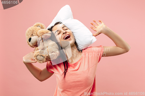 Image of Tired woman sleeping at home having too much work. Bored businesslady with pillow and toy bear