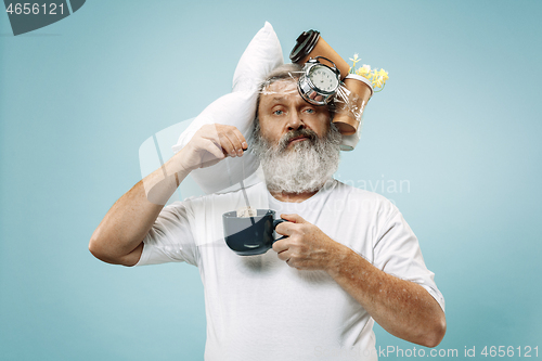 Image of Tired man sleeping at home having too much work. Bored businessman with pillow and hourglass