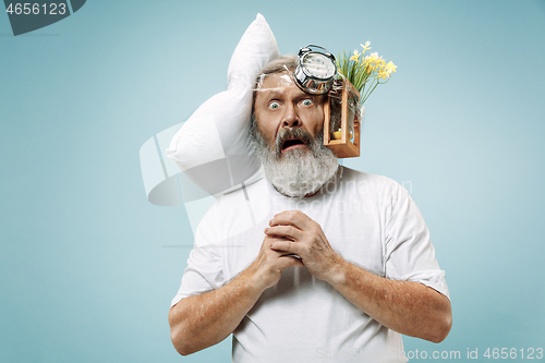 Image of Tired man sleeping at home having too much work. Bored businessman with pillow and hourglass