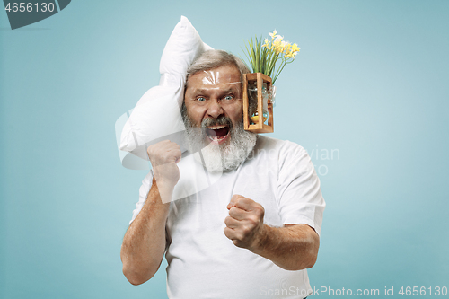 Image of Tired man sleeping at home having too much work. Bored businessman with pillow and hourglass