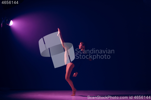 Image of Young female ballet dancer on neon lights studio background.