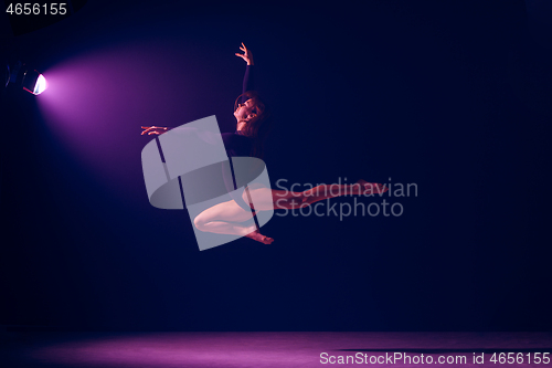 Image of Young female ballet dancer on neon lights studio background.