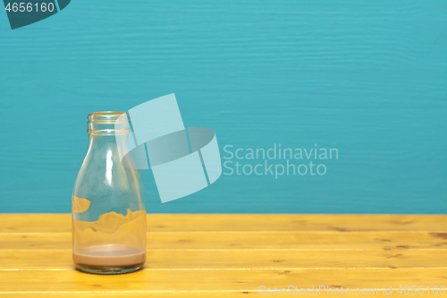 Image of Glass milk bottle with dregs of chocolate milkshake