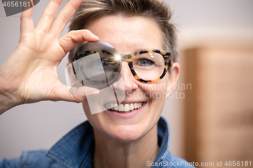 Image of woman with glasses looking through tinted glass