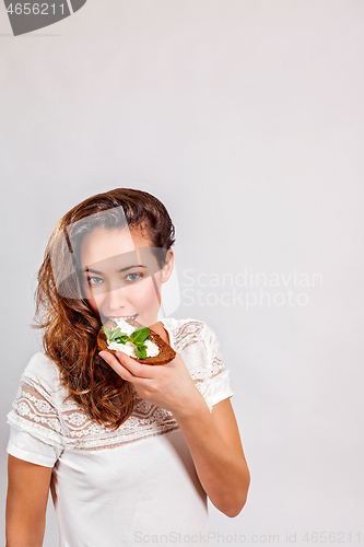 Image of Woman eating bread with cream cheese