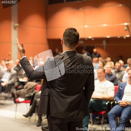 Image of Public speaker giving talk at business event.