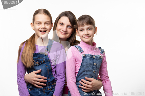 Image of Portrait of a family, mom with two daughters, on a white background