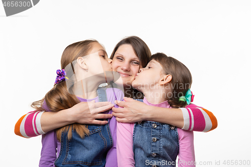 Image of Children joyfully kiss mom, isolated on white background