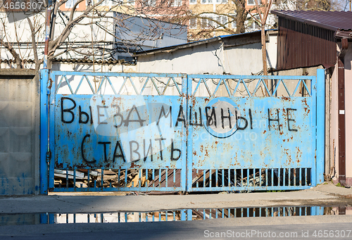 Image of The inscription in Russian on the old gate \"Departure, do not park cars\"