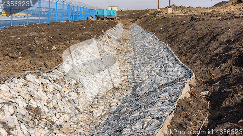 Image of Gabion and gutter construction along the road