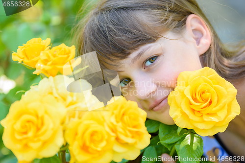 Image of Portrait of a girl of nine years with yellow roses