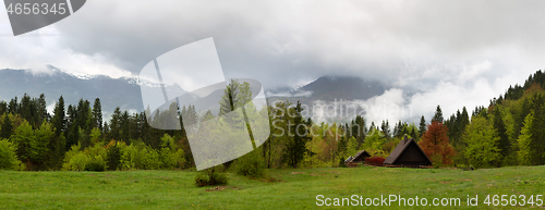 Image of mountain house in fog clouds at spring