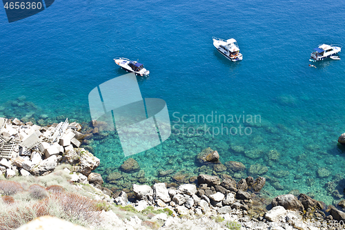 Image of View of the Tremiti Islands. Boats near a rock stone coast.