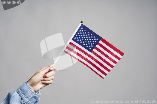 Image of Human hand holding USA flag