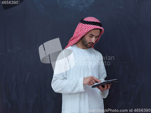 Image of young arabian muslim businessman using tablet computer