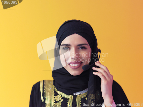 Image of portrait of muslim woman with headset on yellow background