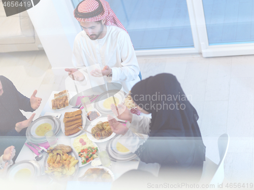 Image of traditional muslim family praying before iftar dinner