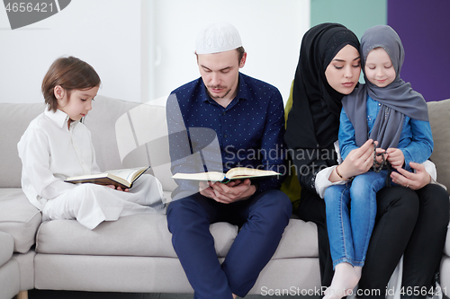 Image of muslim family reading Quran and praying at home