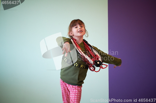 Image of girl having fun and dancing wearing mothers jewelry