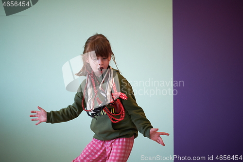 Image of girl having fun and dancing wearing mothers jewelry