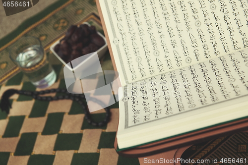 Image of Iftar time Dried Dates, Holy Quran glass of water and tasbih on 