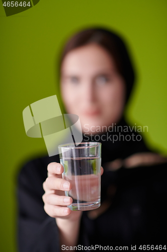 Image of Woman in Abaya Holding a Date Fruit and glass of water