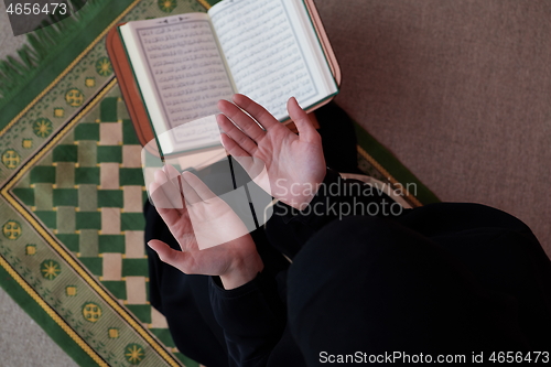 Image of Middle eastern woman praying and reading the holy Quran