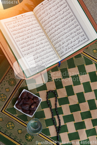 Image of Iftar time Dried Dates, Holy Quran glass of water and tasbih on 