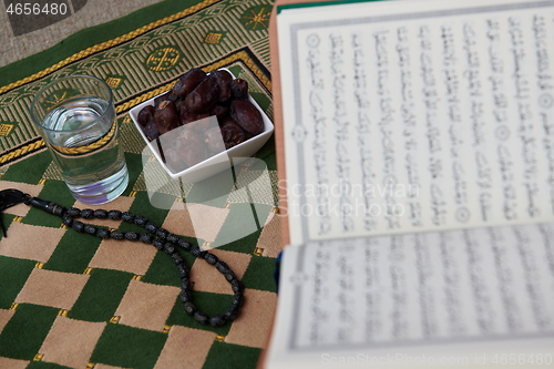 Image of Iftar time Dried Dates, Holy Quran glass of water and tasbih on 