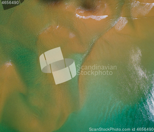 Image of Aerial view of turquoise waves on beach