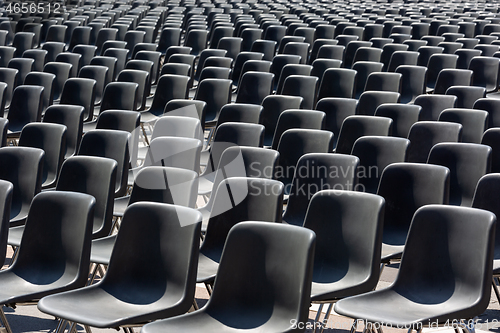 Image of Rows of empty black plastic seats